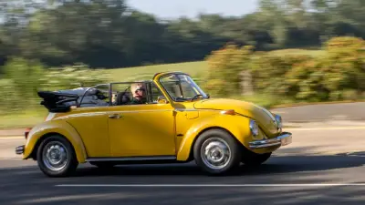 A yellow convertible Volkswagen Beetle
